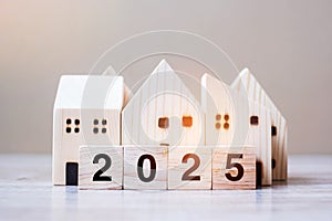 2025 Happy New Year with house model on table wooden background. Banking, real estate, investment, financial, savings and New Year