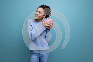 20c young afro hair brunette woman trying to count her piggy bank savings