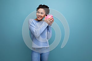 20c young afro hair brunette woman trying to count her piggy bank savings