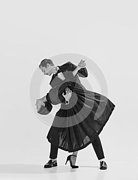 20s-30s era. Beautiful young couple, man and woman in elegant clothes dancing lindy hop. Black and white.