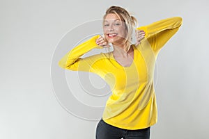 20s blond woman with yellow shirt smiling for wellbeing