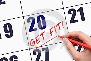 20th day of the month. Hand writing text GET FIT and drawing a line on calendar date. Save the date.