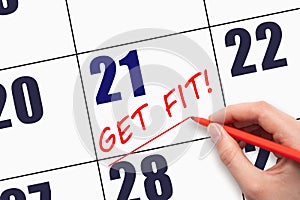 21st day of the month. Hand writing text GET FIT and drawing a line on calendar date. Save the date.
