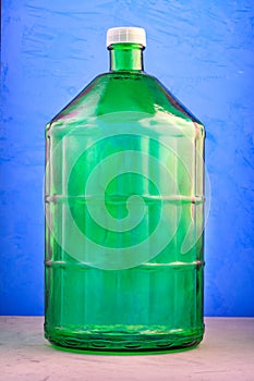 A 22 liter glass jar is made of thick green glass, image on a blue background