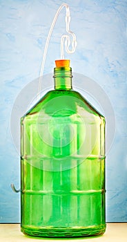 A 22 liter glass jar is made of thick green glass, with a water lockimage on a blue background