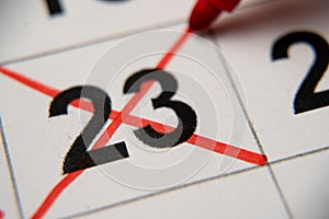 The 23st number in the calendar is crossed out with a red cross in a macro on a white sheet. Calendar for plans, notes