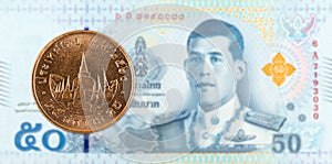 25 thai satang coin against 50 new thai baht banknote