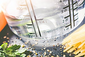 250 ml - ccm Water In A Measuring Cup Surrounded By Noodles, Herbs And Spices