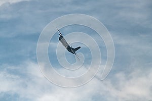 AN-26 plane makes a U-turn at a steep angle before landing at sunny day with cloud sky