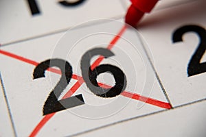 The 26st number in the calendar is crossed out with a red cross in a macro on a white sheet. Calendar for plans, notes