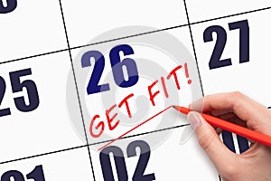 26th day of the month. Hand writing text GET FIT and drawing a line on calendar date. Save the date.