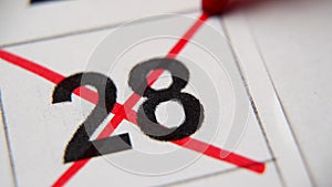 The 28st number in the calendar is crossed out with a red cross in a macro on a white sheet. Calendar for plans, notes