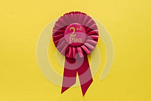 2nd Place red winners ribbon rosette on yellow