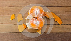 2Orange being peeled on the wooden floor.