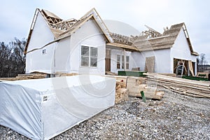 2x4`s and lumber stacked in front of new home construction site