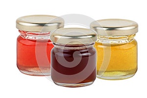 3 cans of multi-colored jams and honey isolated on white background