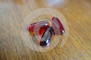 3 capsules of krill oil on wood