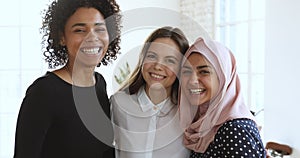 3 cheerful friendly millennial women bonding laughing looking at camera