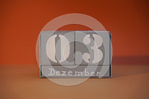 3 Dezember on wooden grey cubes. Calendar cube date 03 December. Concept of date. Copy space for text. Educational cube