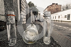 3 empty abandoned small alcohol bottles on the empty street in W