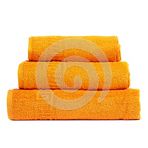 3 frotte towels orange color, bedroom towel white backgroung. Colorful orange bath towels isolated on white. Stack orange towels.