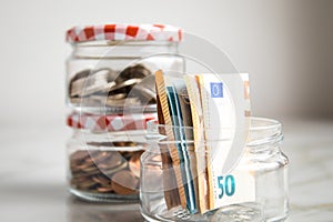 3 glass jars with Euro notes, 2â‚¬ coins and loose cash for housekeeping and savings