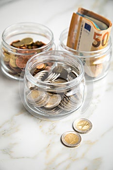 3 glass jars with Euro notes, 2â‚¬ coins and loose cash for housekeeping and savings