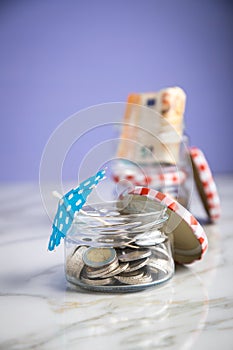 3 glass jars with Euro notes, sunshade, 2â‚¬ coins and loose cash for housekeeping and vacation savings