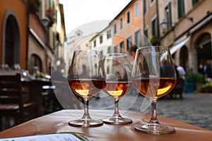 3 glasses of alcohol on a table in a European city