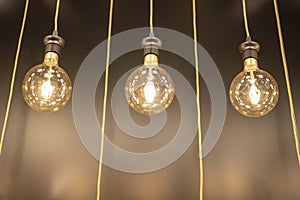 3 incandescent bulbs hanging with wires, Abstract background