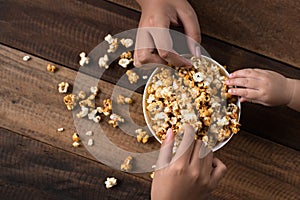 3 kids sharing eating popcorn in a bowl