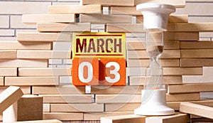 3 Marz on wooden grey cubes. Calendar cube date 03 March. Concept of date.