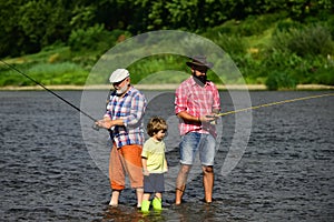 3 men fishing on river in summer time. Grandfather, father and son are fly fishing on river.