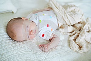 3 months old baby girl sleeping under knitted blanket