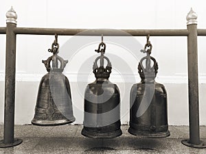3 old bells hung on circular steel beams