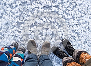 3 pairs of legs, mom, dad and a little son in winter shoes