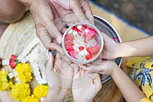 3 people hold silver bowl