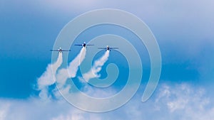 3 performance jets, flying in tandem, on a blue sky with white clouds