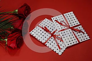 3 red roses with 2 gifts envelopes, red ribbons, certificates, invitation card inside.