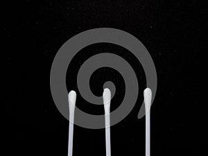 3 sticks of cotton buds in black isolated background