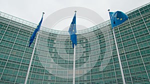 3 waving EU Flags near European Commission Office Building in Brussels, Belgium