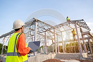 3 Workers in Construction Site, Architect or Engineer technician use a laptop watching team of Workers Steel roof structure under