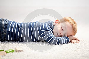 3 year old falling asleep on floor at home photo