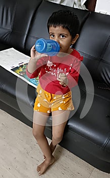 3 years babygirl posing while sipping from her water bottle