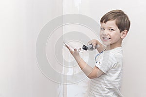 3 years little boy having fun while he is painting at home