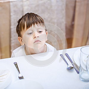 3 years old boy at an empty table