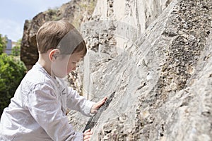 3 years old child touching the rock surface