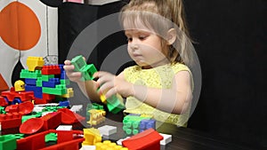3 years old girl playing with coloured blocks of a constructor. The child develops his thinking skills. Development and