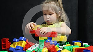 3 years old girl playing with coloured blocks of a constructor. The child develops his thinking skills. Development and