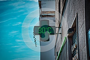 30 degrees celsius, 86 fahrenheit is the temperature displayed by a digital thermometer on a hot summer outside a pharmacy in